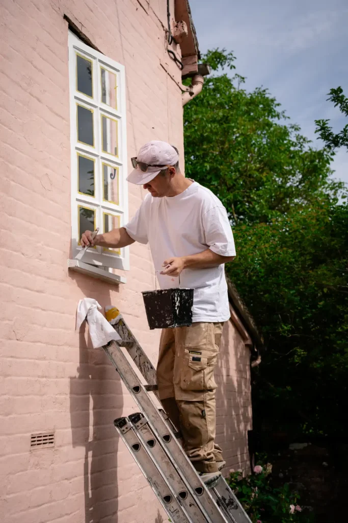 Colour consultation in Suffolk, man painting country house on a ladder.