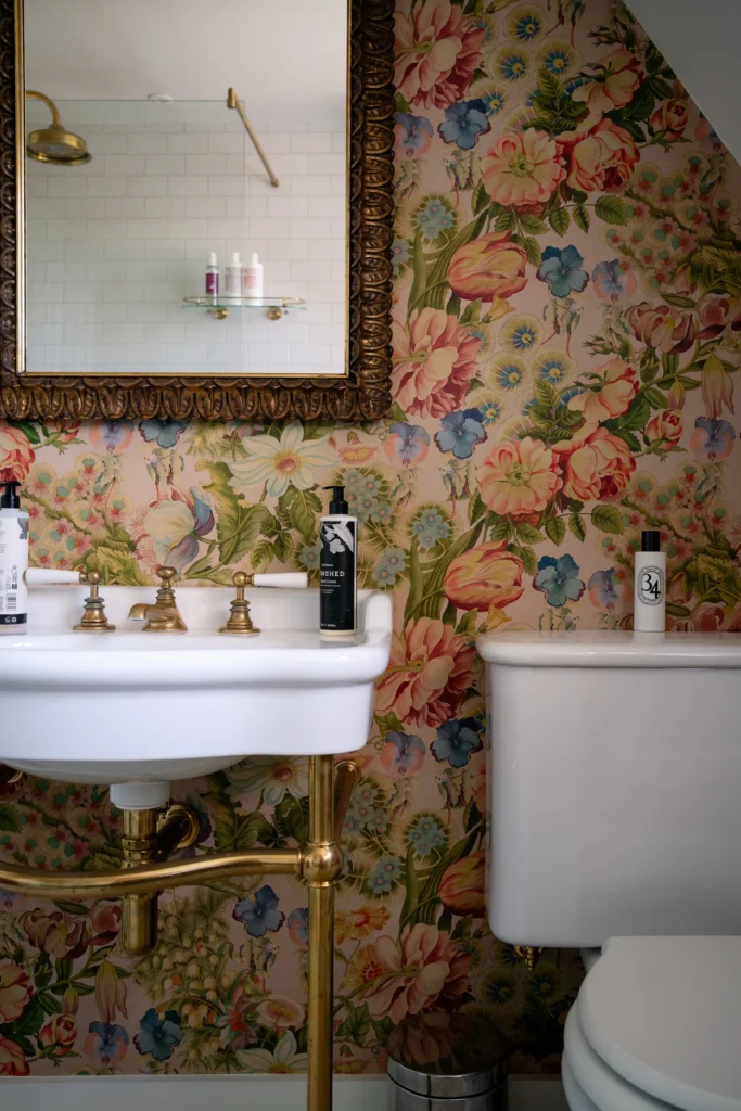 Best wallpapering in Suffolk by Dove Mill, floral wallpaper in a bathroom with sink and toilet in shot.